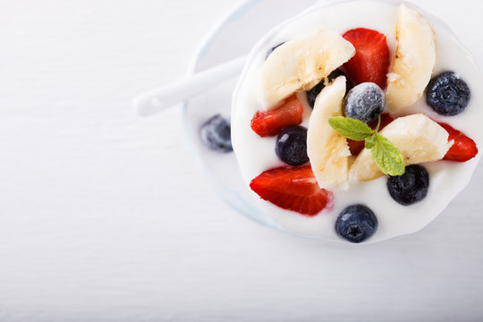 Yogurt,homemade in a ceramic bowl   with berries and mint   on a white background.Breakfast.Healthy food or diet concept. top view.selective focus.