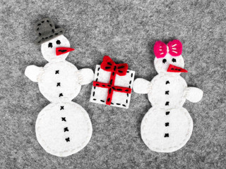 Christmas background with felt decoration: couple of snowman