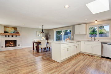 Modern kitchen room interior in white tones with hardwood floor.