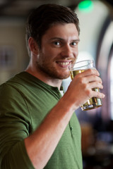 happy man drinking beer at bar or pub