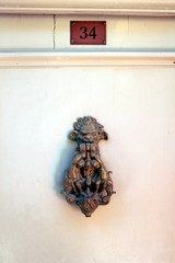 Gothic door knocker with cherubs and monster face and number thirty four