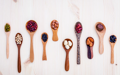 Assortment of beans and lentils in wooden spoon set up on wooden