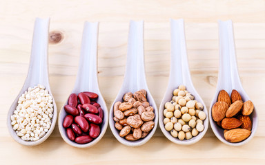 Assortment of beans and lentils in spoon on wooden background. a