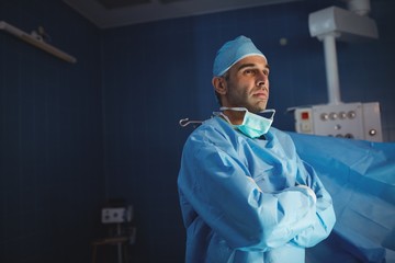 Surgeon standing with arms crossed in operation room