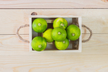 Lemons in a wooden crate on wooden table background.