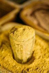 Close Of Turmeric Powder In Glass In Heap Of Bright Yellow Fragrant Spice Condiment