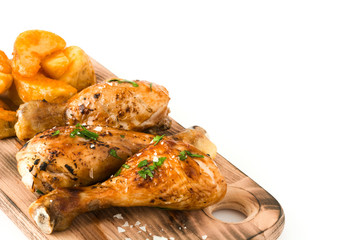 Roast chicken drumsticks on cutting board isolated on white background

