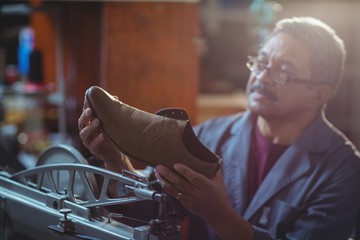 Shoemaker examining a shoe