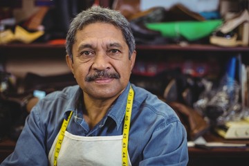 Portrait of shoemaker standing in workshop