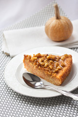 Piece of pumpkin pie with walnuts
