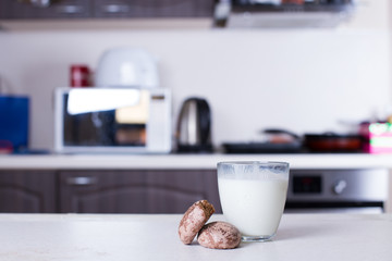 White cup on the kitchen table, with green plant in the background.