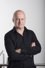 Young white businessman in a black shirt posing in office