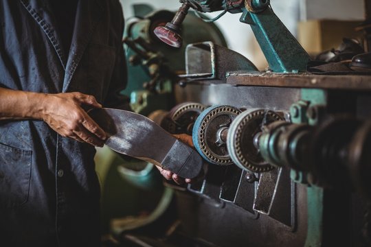 Shoemaker Polishing A Shoe With Machine