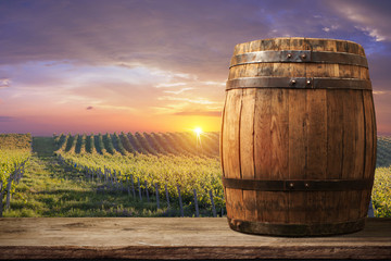 Red wine with barrel on vineyard in green Tuscany, Italy