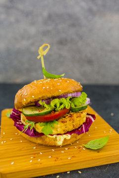 Vegetarian burger with grilled tofu with herbs and raw vegetables. Healthy diet with copy space.
