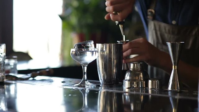 Hands of the barman mixing an alcoholic cocktail at bar