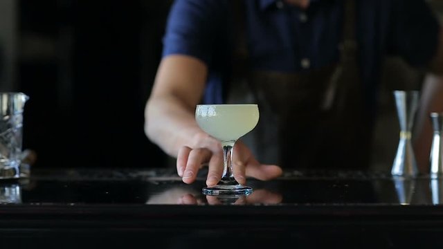 Hands bartender serves cocktail client