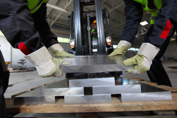 Workers taking aluminium billet