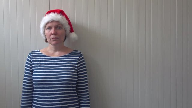 Disappointed woman with Christmas Santa Claus hat suffering from holiday depression, sad and lonely woman waiting New Year all let down