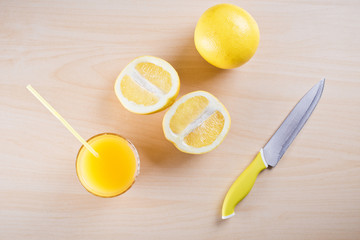 on the table in the kitchen freshly squeezed orange juice , orange slices and whole orange