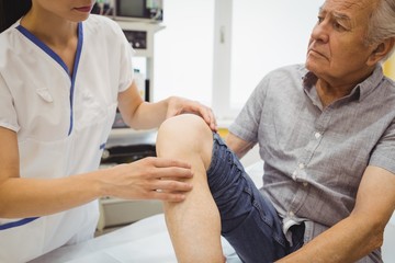 Obraz premium Female doctor examining patients knee