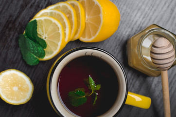 lemon tea with honey and mint on a wooden table, top view