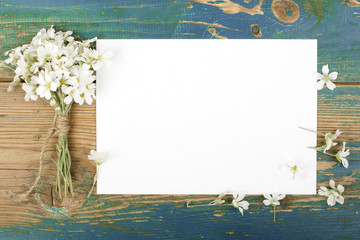 Flowers on vintage wooden planks with blank paper