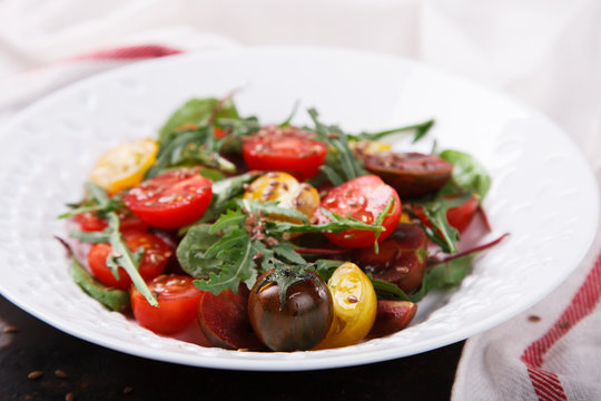 salad of fresh,colored cherry tomatoes with arugula and lemon dressing.selective focus.