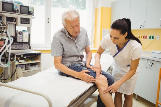 Female Doctor Examining Patients Knee