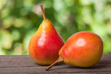 two pears on a dark wooden table with blurred background
