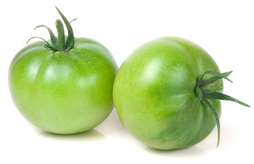 Two green unripe tomato isolated on white background