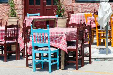Fototapeta na wymiar Wooden chairs and tables at traditional Greek tavern