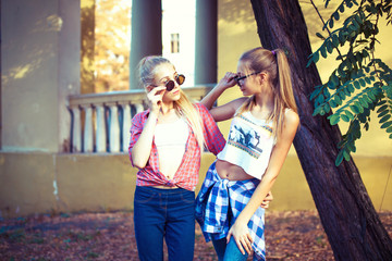 Two young girl friends together in hug at park