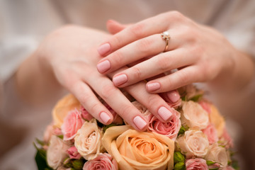 Obraz na płótnie Canvas woman hands on wedding bouquet with engegment ring
