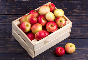 Wooden box full of fresh apples on a wooden background