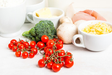 The selection of ingredients for the preparation of traditional French dishes quiche lorraine, on white wooden table, close view