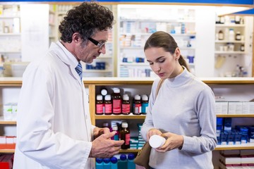 Pharmacist assisting the bottle of drug to customer