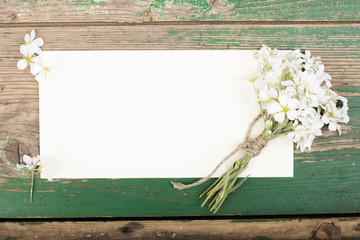 Flowers on vintage wooden planks with blank paper