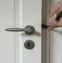 Naklejka premium Burglar trying to break into a house with a crowbar