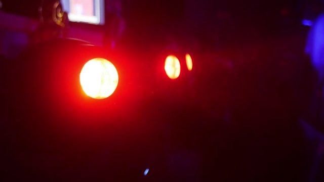 Red turning searchlights in nightclub. Bright color. Spotlights