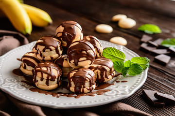 Round sponge biscuits stuffed with banana slices and topped with chocolate