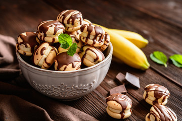 Round sponge biscuits stuffed with banana slices and topped with chocolate