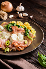 Roasted pork cutlets with bacon, cheese, spinach and potatoes