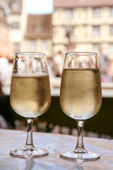 due calici di vino bianco  riesling , sullo sfondo di una piazza di Colmar in Alsazia. 