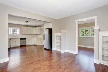 White kitchen room interior with marble counter top and hardwood floor.