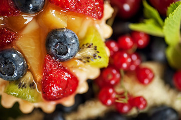 mix of fresh berries and  cheesecake on rustic dark grey wooden desk