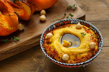 pumpkin hummus on a dark wood background. selective focus