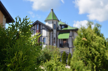 Fototapeta na wymiar Hidden green and white residence building in castle style