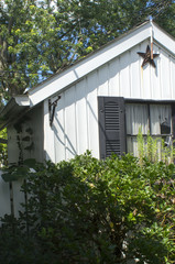 A small shed with some ornamentation where garden toold are stored.