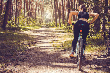 Fototapeta premium Woman riding a bicycle in the forest